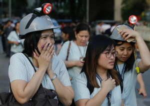 22일(현지시간) 오후 5시11분께 필리핀 북부 루손섬 인근에서 규모 6.3 지진이 발생해 수도 마닐라까지 지진 충격이 전해지자 놀란 시민이 헬멧을 쓰고 건물 밖으로 대피하고 있다. /마닐라=AP연합뉴스