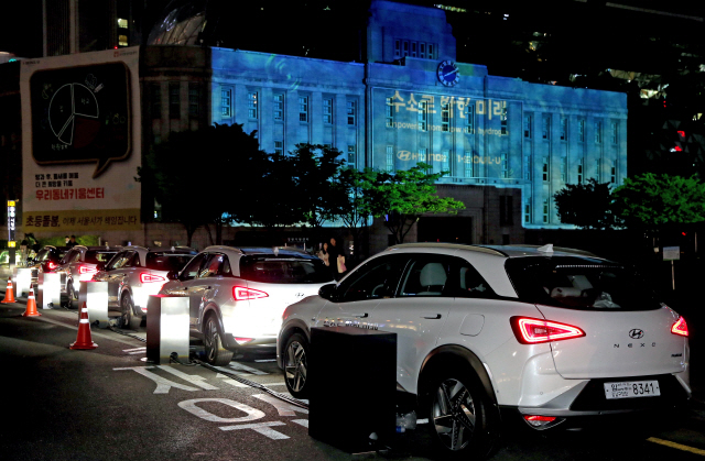 지난 22일 현대자동차가 지구의 날을 맞아 수소전기차 넥쏘의 연료전지를 이용해 만든 수소 에너지 이미지 영상을 서울도서관(옛 서울시청) 외벽에 투사하고 있다. /사진제공=현대차
