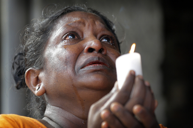 ‘부활절 연쇄 폭발 테러’ 가 발생한 스리랑카 수도 콜롬보의 성 안토니오 성당 인근에서 23일(현지시간) 한 여성이 눈물을  흘리며 촛불을 들고 있다. /콜롬보=AP연합뉴스