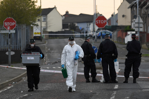 경찰이 지난 19일(현지시간) 기자인 리라 맥키가 피살된 북아일랜드 런던데리에서 증거품을 담은 상자를 옮기고 있다.       /런던데리=로이터연합뉴스