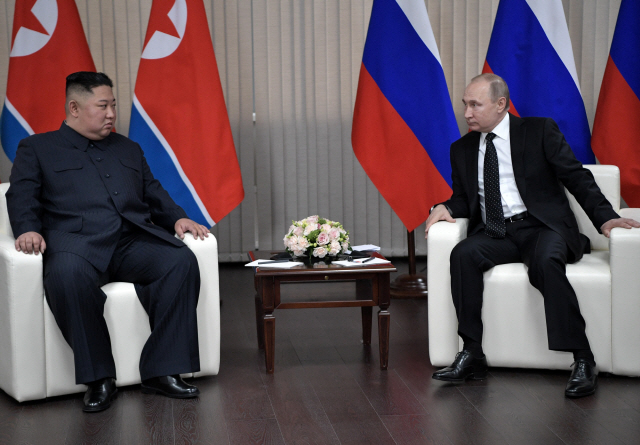 김정은(왼쪽) 북한 국무위원장과 블라디미르 푸틴 러시아 대통령이 25일 블라디보스토크 극동연방대에서 만나 정상회담을 하고 있다.   /블라디보스토크=로이터연합뉴스