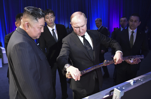 블라디미르 푸틴 러시아 대통령이 25일 김정은 북한 국무위원장에게 선물 받은 칼을 살펴보고 있다./AP연합뉴스