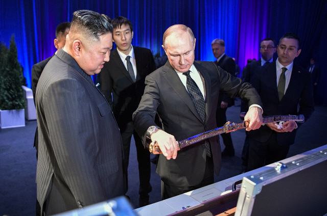 블라디미르 푸틴 러시아 대통령이 25일 블라디보스토크 극동연방대학에서 김정은 북한 국무위원장에게 선물 받은 칼을 살펴보고 있다./AP연합뉴스