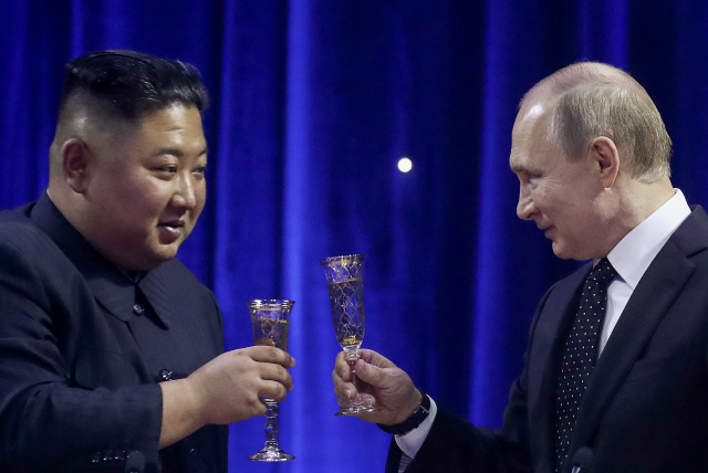 김정은(왼쪽) 북한 국무위원장과 블라디미르 푸틴 러시아 대통령이 25일 러시아 블라디보스토크 극동연방대에서 정상회담을 마친 뒤 저녁 만찬장에서 건배를 하고 있다./블라디보스토크=타스연합뉴스