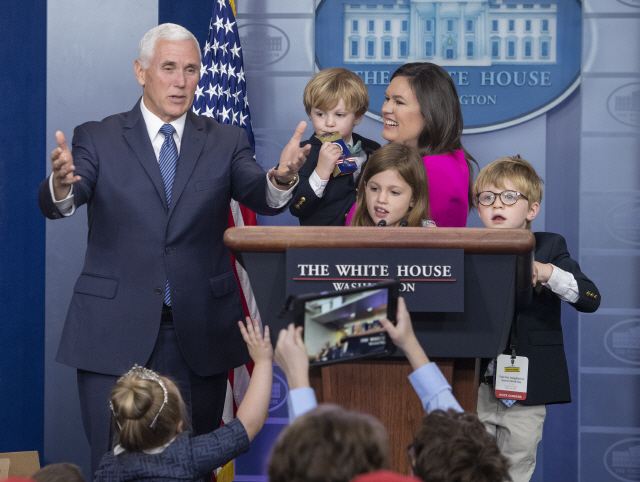마이크 펜스(왼쪽) 미국 부통령과 자신의 아이들과 함께 있는 세라 샌더스 대변인이 25일(현지시간) 백악관에서 참모진과 출입기자단 자녀들로부터 질문을 받고 있다. /워싱턴=UPI연합뉴스