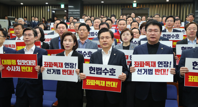 황교안(앞줄 오른쪽 두번째) 자유한국당 대표와 나경원(〃왼쪽 두번째) 원내대표 등 의원들이 29일 오전 여의도 국회에서 열린 비상의원총회에서 손팻말을 들고 구호를 외치고 있다. /연합뉴스