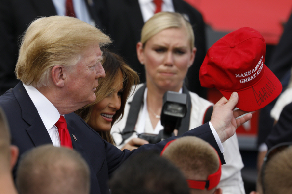 지난해 7월4일(현지시간) 도널드 트럼프(왼쪽) 미국 대통령이 군 가족들과의 만남에서 “Make America Great Again(미국을 다시 위대하게 만들자)”이라고 쓰인 모자를 든 채 사람들에게 인사를 건네고 있다./워싱턴=블룸버그