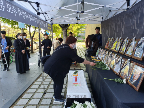 가습기살균제 피해자가 2일 서울 영등포구 옥시 본사 앞에 설치된 시민분향소에서 헌화를 하고 있다./이희조기자