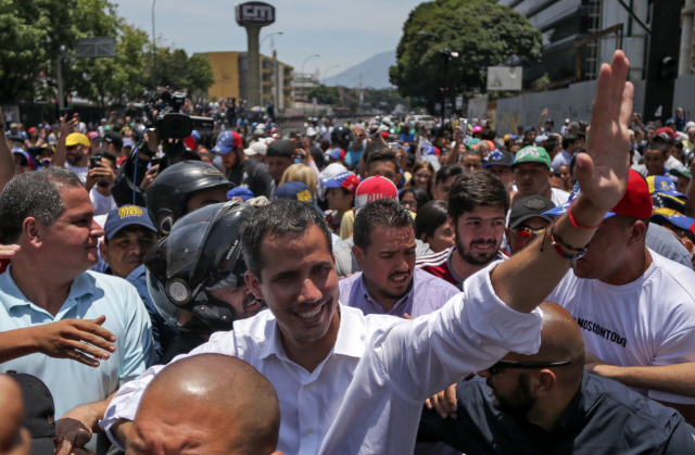 베네수엘라 임시 대통령을 자처하는 후안 과이도(가운데) 국회의장이 1일(현지시간) 베네수엘라 수도 카라카스에서 열린 반정부 시위에서 시위 참가자들을 향해 손을 흔들고 있다. /카라카스=AFP연합뉴스