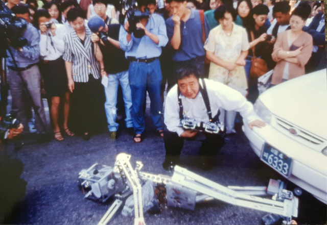 백남준이 1995년 서울 박영덕화랑에서 열린 개인전에 맞춰 새로 제작한 로봇 ‘K-567’이 청담동 대로에서 자동차에 치어 ‘죽게’ 하는 ‘길 위의 로봇’ 퍼포먼스를 펼치고 있다. /사진제공=박영덕화랑