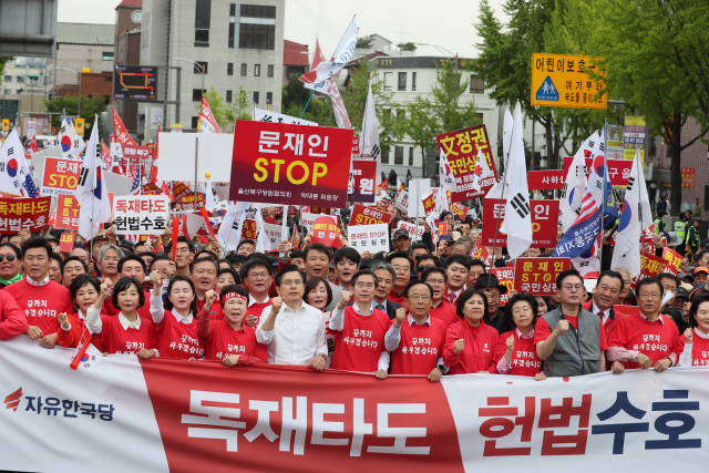 황교안(왼쪽 여섯번째) 자유한국당 대표와 의원들이 지난달 27일 서울 광화문광장에서 열린 ‘문재인 STOP(멈춤), 국민이 심판합니다!’에서 청운효자동주민센터를 지나 청와대로 행진하고 있다. /연합뉴스