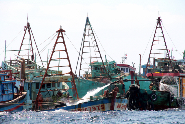 4일 인도네시아 해역 인근에서 인부들이 불법조업을 하다 나포된 베트남 어선에 물을 채워 침몰시키고 있다./로이터연합뉴스