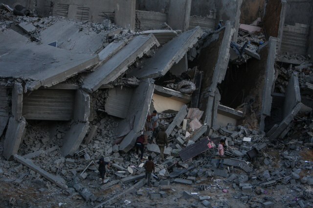 5일(현지시간) 팔레스타인 자치령인 가자지구의 중심 도시에서 주민들이 전날 이스라엘군의 공습으로 무너진 건물의 잔해를 살피고 있다. /가자시티=신화연합뉴스