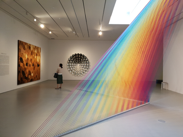 가브리엘 다우의 작품(앞쪽)은 320개의 색실로 빛의 스펙트럼을 환상적으로 보여주고, 올라퍼 엘리아슨은 나무와 유리구슬을 소재로 독특한 시각경험을 제공한다./조상인기자