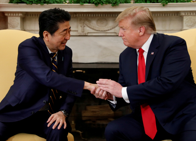 도널드 트럼프(오른쪽) 미국 대통령과 아베 신조 일본 총리가 지난달 26일(현지시간) 백악관에서 악수를 나누고 있다. /워싱턴DC=로이터연합뉴스