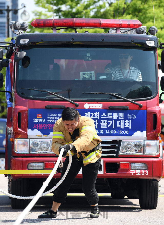 9일 오후 서울 영등포구 여의도공원에서 열린 '제2회 스트롱맨 소방차 끌기 대회'에 참가한 소방관이 맨몸으로 11t의 소방차를 끌고 있다./오승현기자 2019.5.9