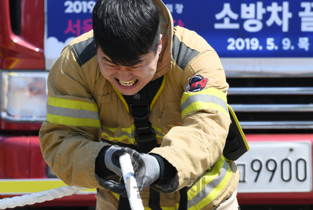 9일 오후 서울 영등포구 여의도공원에서 열린 '제2회 스트롱맨 소방차 끌기 대회'에 참가한 소방관이 맨몸으로 11t의 소방차를 끌고 있다./오승현기자 2019.5.9