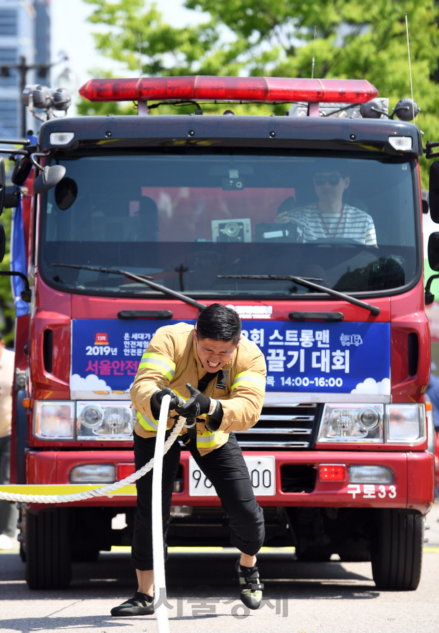 9일 오후 서울 영등포구 여의도공원에서 열린 '제2회 스트롱맨 소방차 끌기 대회'에 참가한 소방관이 맨몸으로 11t의 소방차를 끌고 있다./오승현기자 2019.5.9