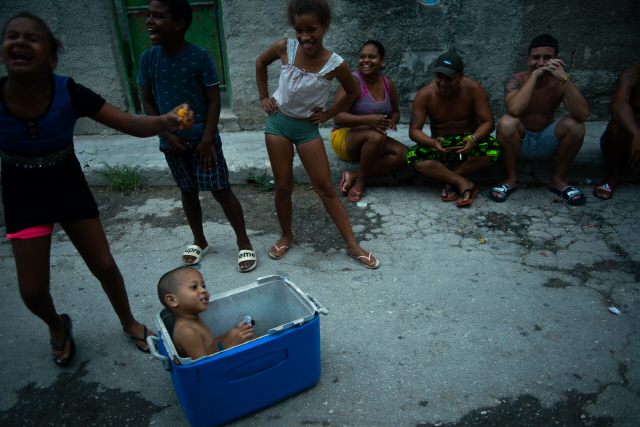 쿠바 아바나 인근 자이마니타스 거리에서 어린이와 이웃들이 즐겁게 웃고있다./AP연합뉴스