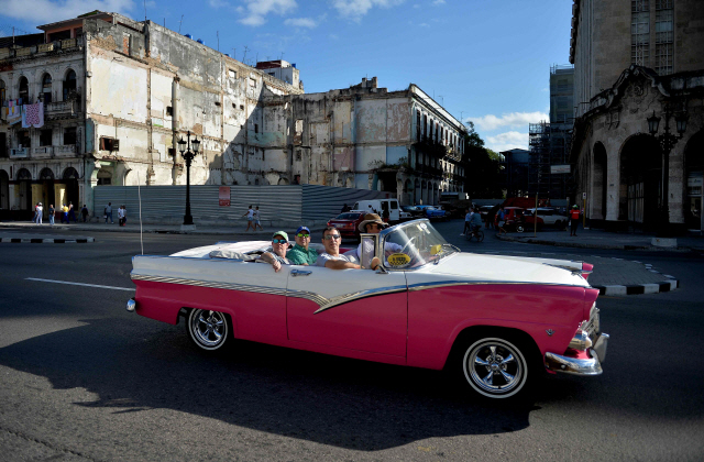 아바나에서 관광객들이 택시 역할을 하는 낡은 미국 차를 타고 있다. /AFP연합뉴스