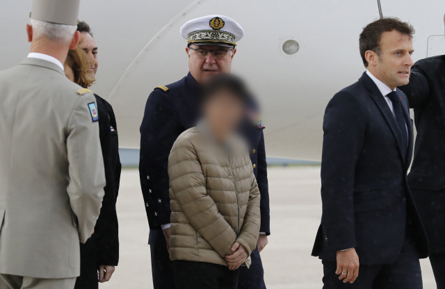 에마뉘엘 마크롱(오른쪽) 프랑스 대통령이 11일 파리 근교 빌라쿠블레 공항에서 아프리카 무장세력에 납치됐다가 프랑스 특수부대에 구출된 한국인 여성(가운데) 등과 함께 활주로를 걸어가고 있다.    /빌라쿠블레=AP연합뉴스