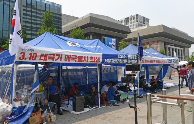 12일 서울 광화문광장에 설치된 대한애국당 천막에 관계자들이 모여 있다. 서울시는 애국당 측에 13일 오후 8시까지 자진 철거하지 않을 경우 행정대집행에 나서겠다는 입장을 전달했다.  /성형주기자