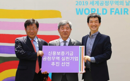 11일 서울 성동구 서울숲에서 진행된 ‘2019 세계 공정무역의 날 한국 페스티벌’에서 조경식(가운데) 신용보증기금 이사가 한국공정무역협의회, 한국공정무역마을위원회와 함께 공정무역 실천기업 추진을 선언하고 있다. 신보는 이번 선언을 통해 ▲공정무역 제품 사용 확대 ▲공정무역의 필요성 홍보 ▲공정무역에 대한 교육 ▲공정무역 기업 지원 강화 등 공정무역 활성화를 위한 실천의지를 밝히고 기관운영 전반에 윤리적 소비를 실천해 공정무역의 대중화를 선도할 계획이다./사진제공=신용보증기금