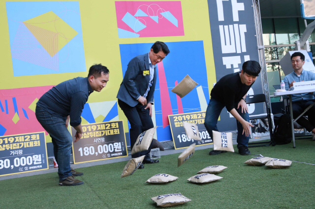 박준희(가운데) 관악구청장이 지난 11일 ‘2019 관악청년축제’에서 청년들과 딱지를 뒤집고 있다.    /사진제공=관악구