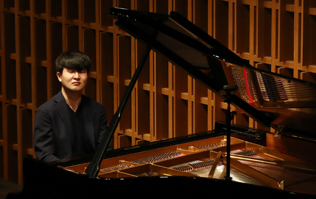 피아니스트 선우예권이 13일 열린 기자간담회에서 직접 로베르트 슈만의 곡을 연주하고 있다. /연합뉴스