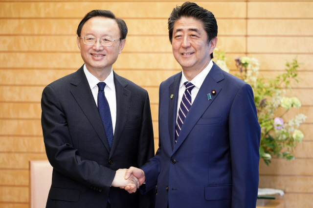 아베 신조(오른쪽) 일본 총리와 양제츠 중국 외교담당 정치국원이 17일 도쿄 총리 관저에서 악수하고 있다. /도쿄=AFP연합뉴스