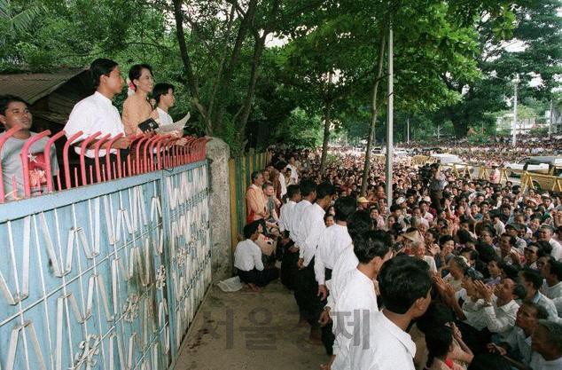 가택 연금 상태의 아웅산 수지가 자신의 집 앞에 몰려든 국민들을 향해 인사를 하고 있다./사진제공=연합뉴스
