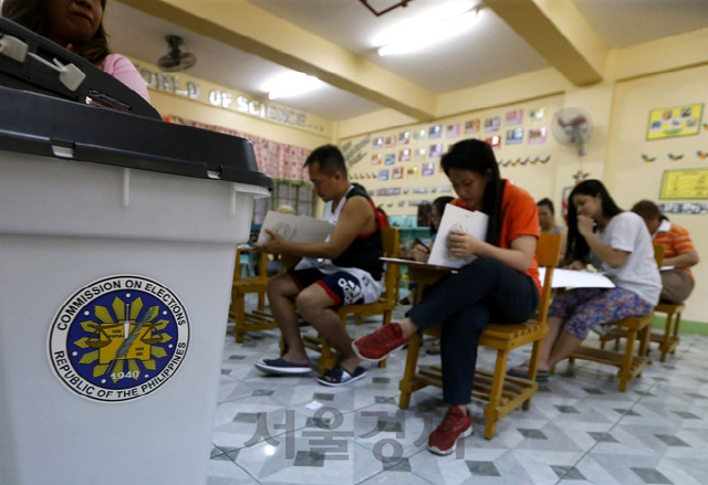 필리핀에서 중간선거일인 13일(현지시간) 마닐라의 한 학교에 마련된 투표소를 찾은 유권자들이 투표를 하고 있다. /AP 연합뉴스