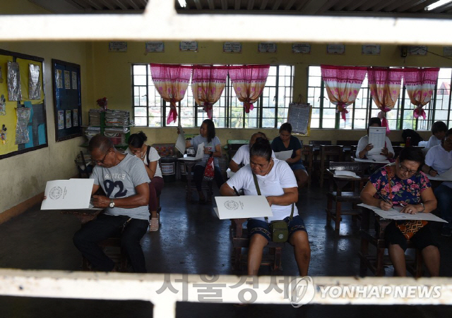 필리핀에서 중간선거일인 13일(현지시간) 마닐라의 한 학교에 마련된 투표소를 찾은 유권자들이 투표를 하고 있다. /AFP=연합뉴스