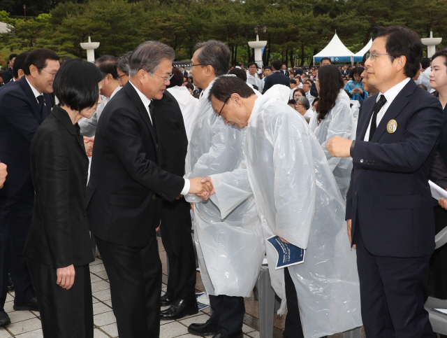 문재인 대통령이 18일 오전 광주 국립5·18민주묘지에서 열린 5·18 민주화운동 기념식장에 입장하며 이해찬 더불어민주당 대표와 악수하고 있다. /광주=연합뉴스