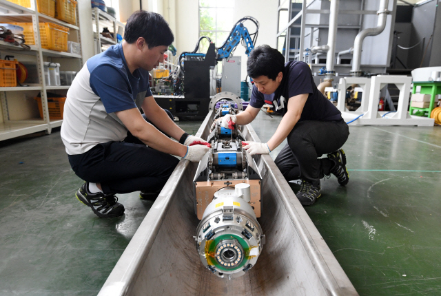 한국로봇융합연구원 연구진이 가스배관 검사 로봇을 점검하고 있다. /포항=권욱기자