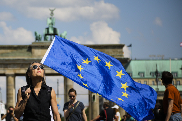 한 여성이 19일(현지시간) 베를린에서 열린 집회에서 유럽연합(EU) 기를 들고 있다. /베를린=AP연합뉴스