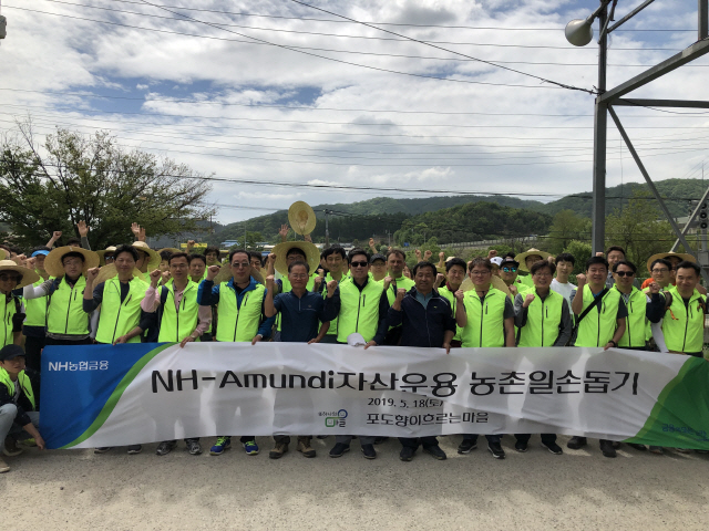 지난 18일 경기도 가평군의 한 농가에서 진행된 ‘NH-아문디자산운용 농촌일손돕기’ 행사에서 박규희(앞줄 오른쪽 일곱번째) 대표와 임직원 봉사단이 일손돕기 후 기념촬영을 하고 있다./사진제공=농협금융지주