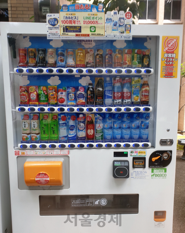 일본 도쿄의 한 대학 캠퍼스에 ‘비상시 구명 자판기’라는 스티커(오른쪽 위)가 붙은 재난 대응 자판기가 설치돼 있다. 비상시 왼쪽 아래의 노란 뚜껑을 열어 특수 핸들을 돌리면 무료로 음료를 꺼내 마실 수 있다./송주희기자
