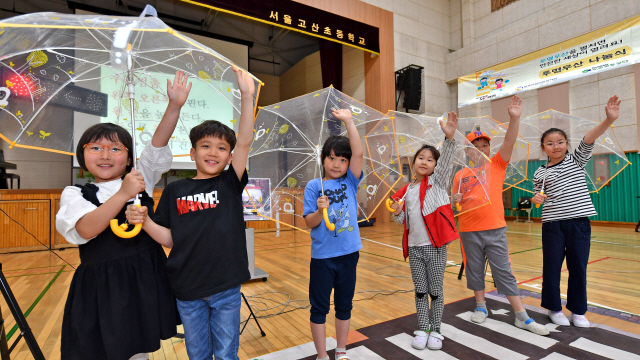 서울 고산초등학교 학생들이 지난 20일 현대모비스가 배포한 투명우산을 들고 포즈를 취하고 있다. /사진제공=현대모비스