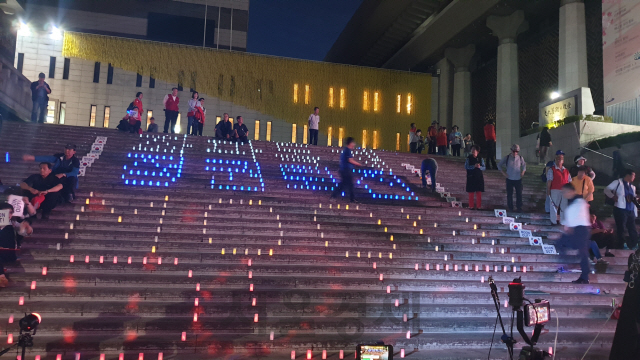 자유한국당 당원들이 25일 세종문화회관 계단에 ‘좌파독재 정권퇴진 MOON OUT’이라고 적힌 LED등을 켜놓고 있다./김인엽기자