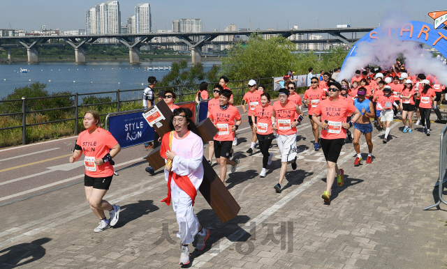 '제3회 롯데 스타일런'이 열린 26일 오전 서울 광진구 뚝섬 한강공원에서 독특한 의상으로 각자의 개성을 뽐낸 참가자들이 힘차게 출발하고 있다. 롯데 유통사업부문이 주최한 이번 대회에서 5천여 명의 참가자들이 대한육상연맹(KAAF)에서 인정한 공식 코스를 마음껏 달렸다./오승현기자 2019.5.26