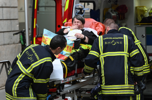 프랑스 남부 대도시 리옹의 구도심에서 지난 24일(현지시간) 사제폭탄 테러가 발생해 응급구조대원들이 부상자를 구급차로 옮기고 있다.     /파리=AFP연합뉴스