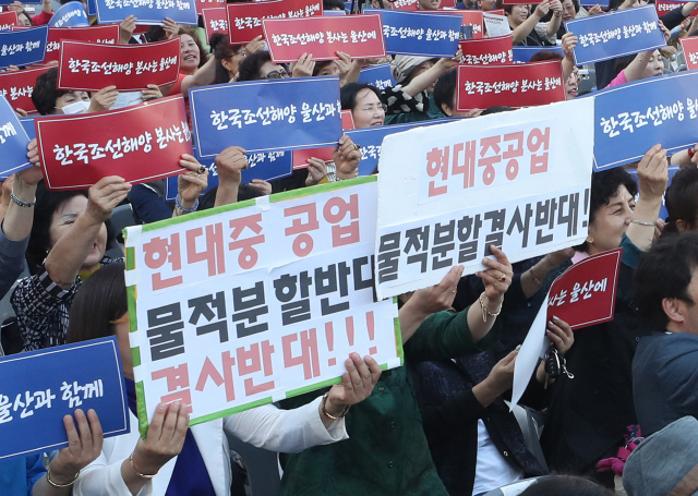 지난 22일 울산시청 앞에서 열린 ‘한국조선해양 본사 울산 존치 범시민촉구대회’에 참가한 시민이 팻말을 들고 구호를 외치고 있다. 한국조선해양은 현대중공업 물적 분할에 따라 설립되는 중간지주회사다./연합뉴스