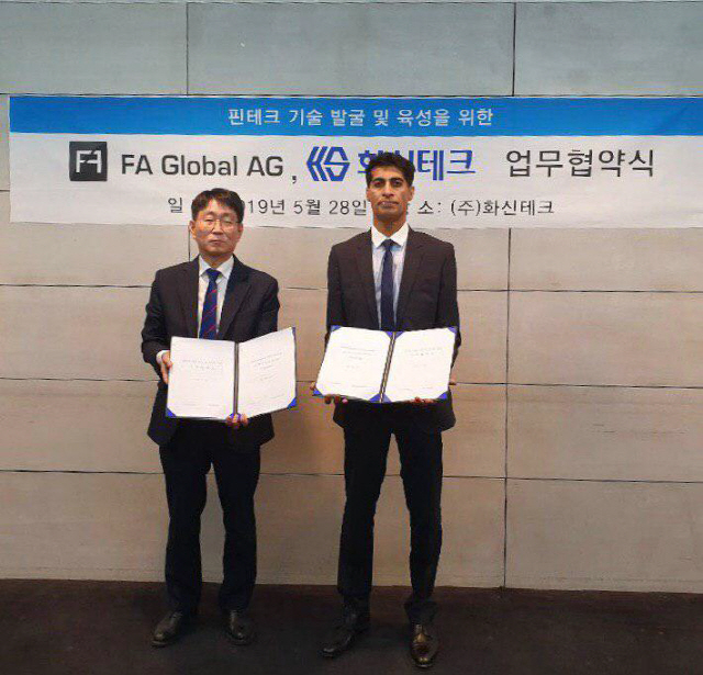 백승덕(왼쪽) 화신테크 대표와 파이로즈 칸(Firoze Khan) FA Global AG 대표가 28일 서울 강남구 화신테크 사무실에서 양해각서를 나란히 펼치고 있다./사진제공=화신테크