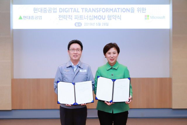 김태환(왼쪽) 현대중공업 최고 디지털 책임자와 이지은 한국마이크로소프트 엔터프라이즈 글로벌 사업본부 부사장이 디지털 트랜스포메이션을 위한 전략적 파트너십 체결안을 들어올려보이고 있다./사진제공=한국마이크로소프트