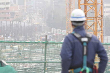 서울시내의 한 건설현장에서 건설노동자가 미세먼지 가득한 작업장을 바라보고 있다. /연합뉴스