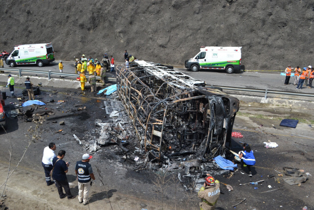 Rescue personal work at the site of a road accident in Coatzacoalcos, state of Veracruz, Mexico on May 29, 2019. - A semi truck and a bus carrying passengers back from a pilgrimage to a Catholic shrine crashed and burst into flames Wednesday in eastern Mexico, killing at least 21 people, officials said. (Photo by GUILLERMO CARREON / AFP)        <저작권자(c) 연합뉴스, 무단 전재-재배포 금지>