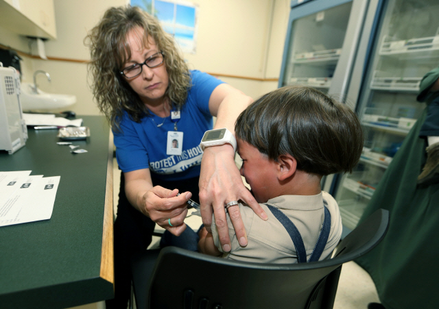 한 남자 아이가 이달 17일(현지시간) 오하이오주 마운트버논 보건시설에서 백신 주사를 맞고 있다. /마운트버논=AP연합뉴스