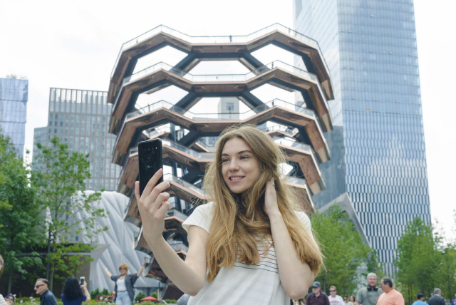 LG전자 모델이 미국 뉴욕의 건축물 ‘베슬(Vessel)’ 앞에서 LG V50 씽큐로 셀피 촬영을 하고 있다./사진제공=LG전자