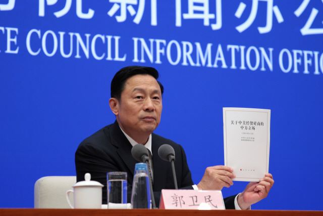궈웨이민 중국 국무원 신문판공실 부주임이 2일 베이징에서 열린 기자회견에서 발표한 ‘중미무역협상에 관한 중국의 입장’이라는 제목의 백서를 들어 보이고 있다.   /베이징=로이터연합뉴스